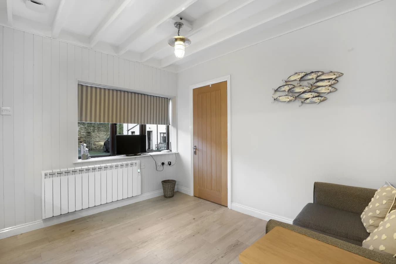 Bright open-plan interior with TV area and light timber flooring