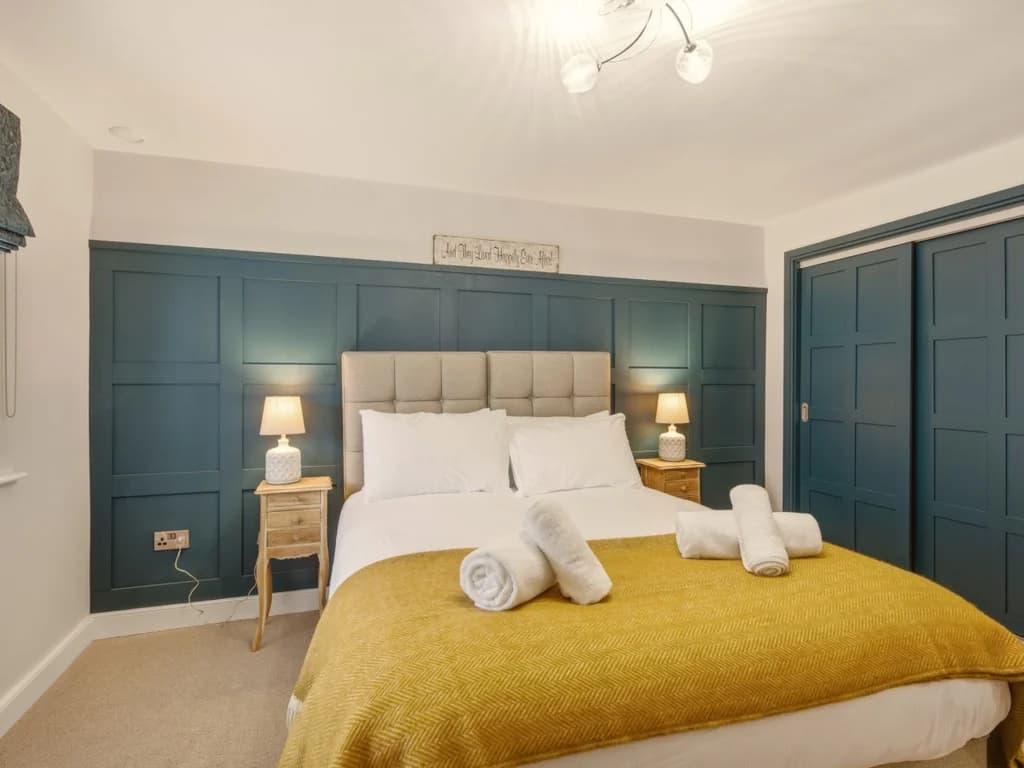Spacious zip-link king bedroom with panelled feature wall and bedside lighting