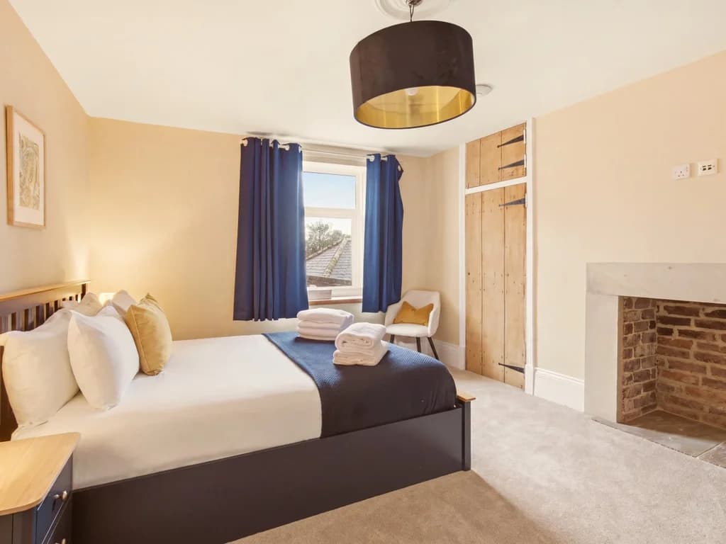 Queen bedroom with feature fireplace and built-in wardrobe.