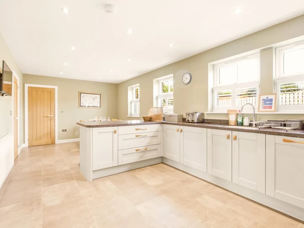 Spacious contemporary kitchen with extensive cabinetry and worktops