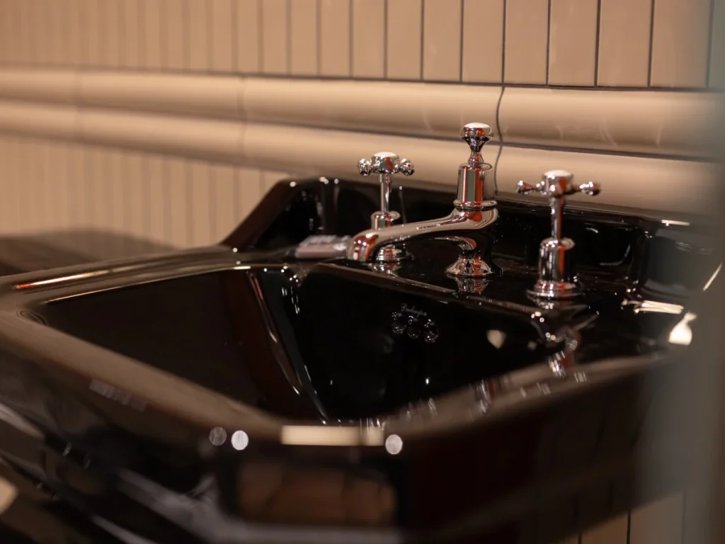 Close-up of the black ceramic basin with traditional chrome taps