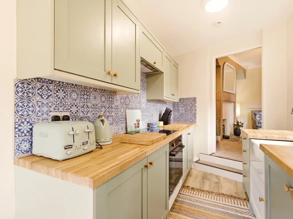 Galley kitchen with shaker cabinets and wood-effect worktops.