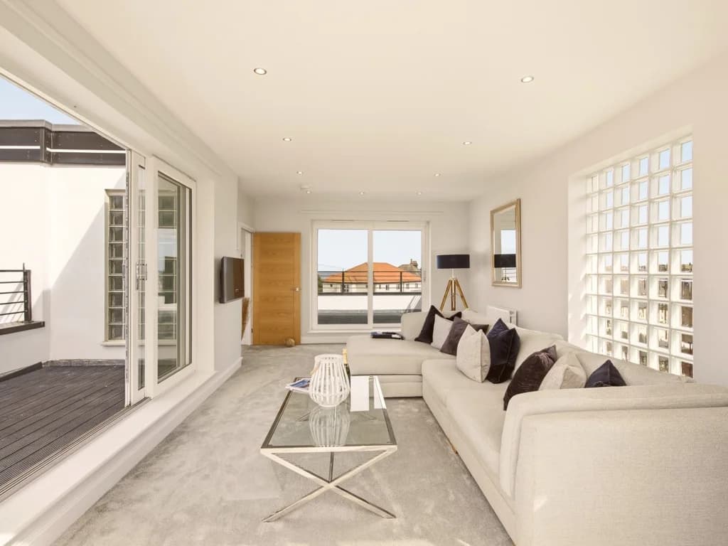 Spacious lounge opening onto the balcony with elevated views towards the coast