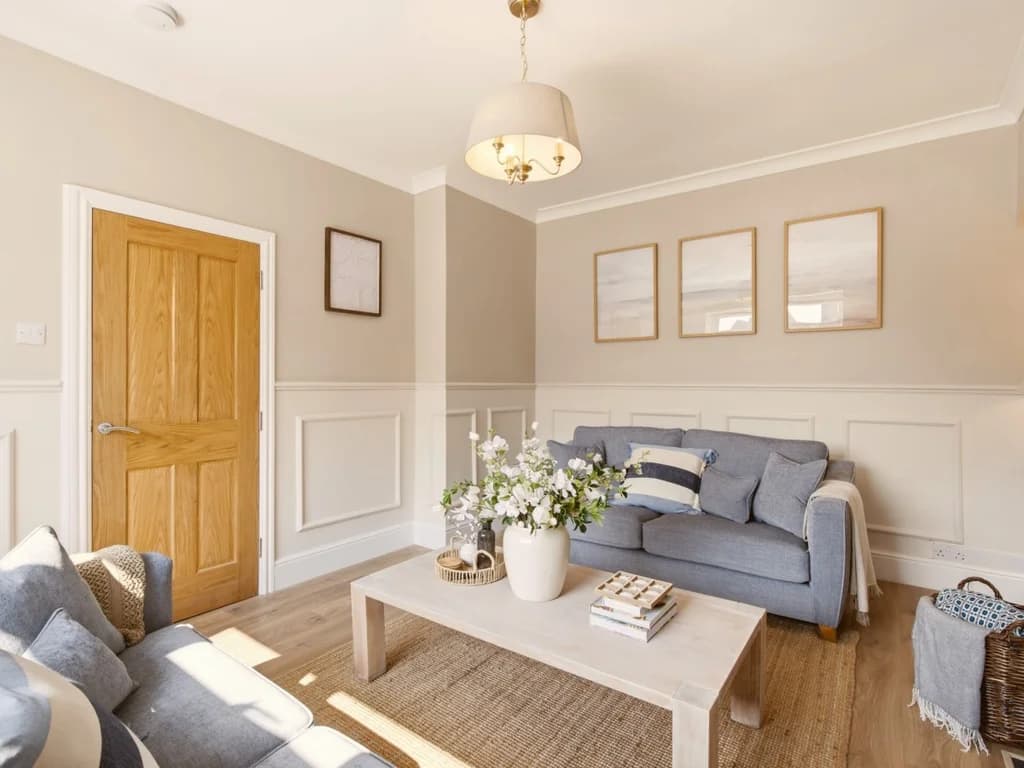 Comfortable lounge with grey sofas, wood flooring and neutral décor