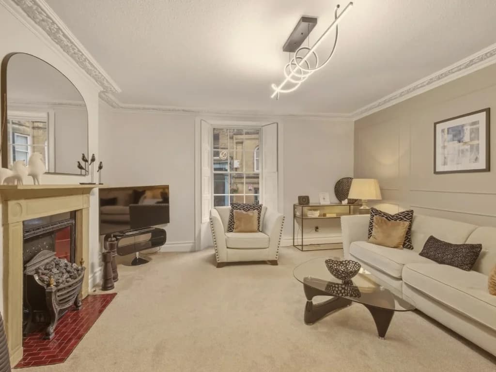 Comfortable living room with cream seating, Smart TV and feature fireplace