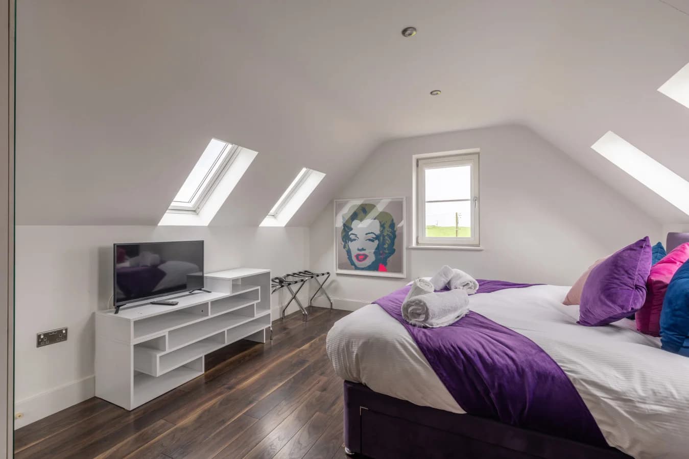 King bedroom with skylights, oak flooring and Smart TV