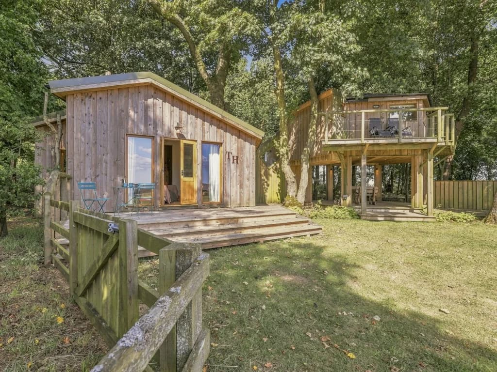 Treehouse accommodation surrounded by trees within Rose’s Bower