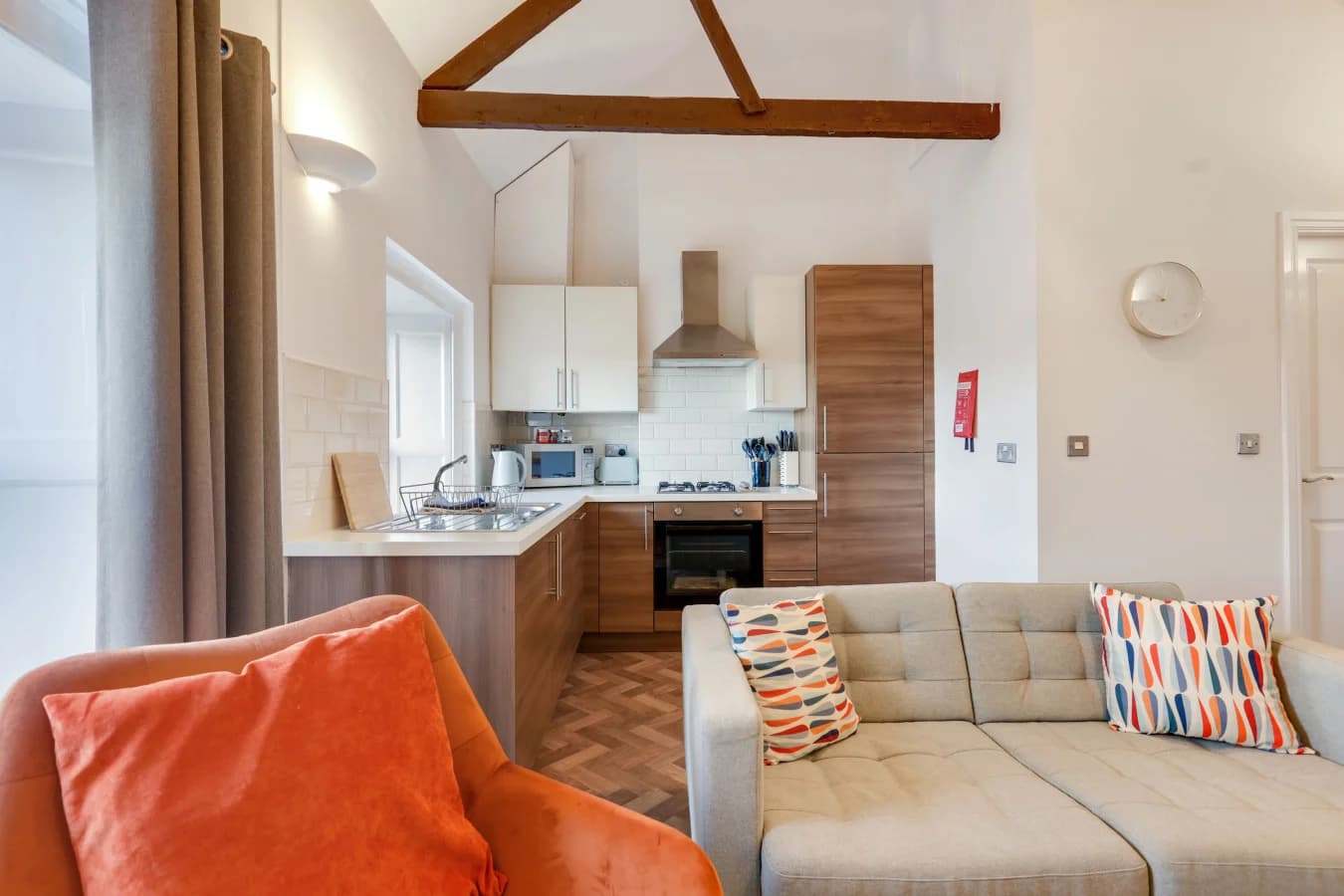 Spacious living and kitchen area beneath characterful exposed beams