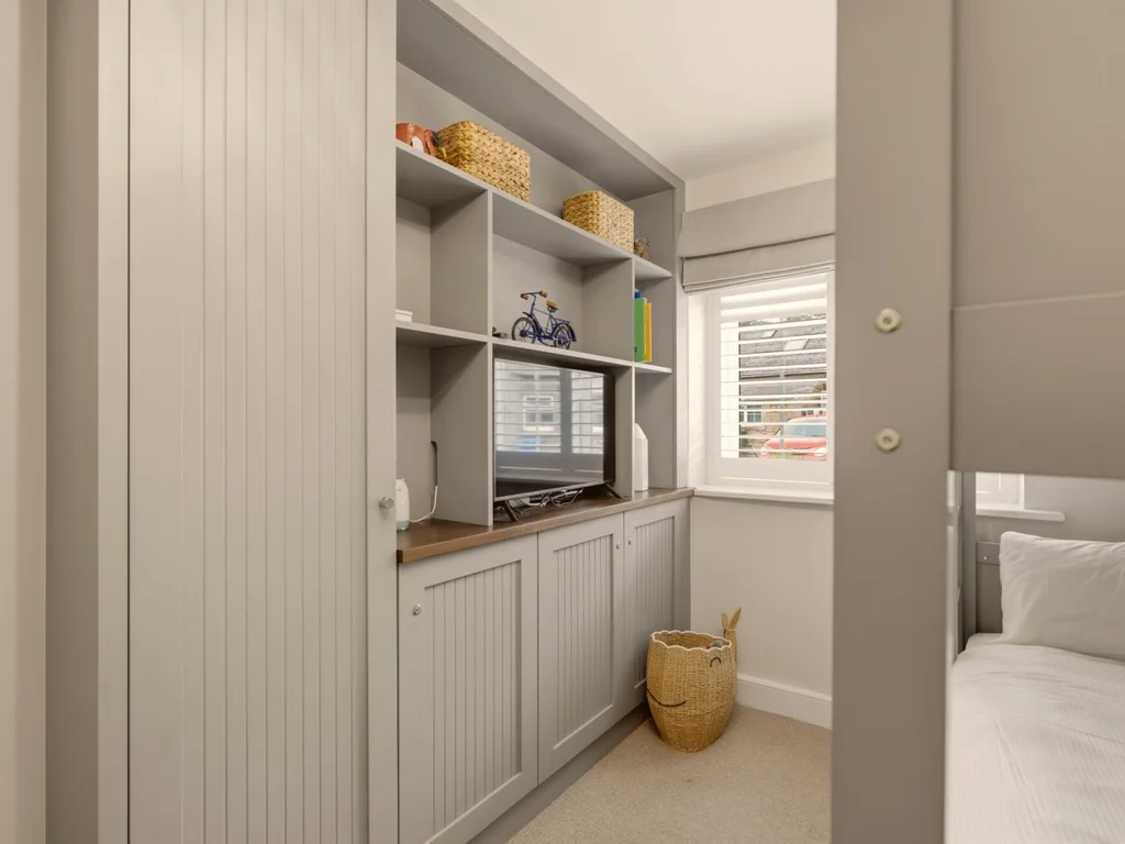 Custom built-in storage with Smart TV and workspace in the bunk bedroom