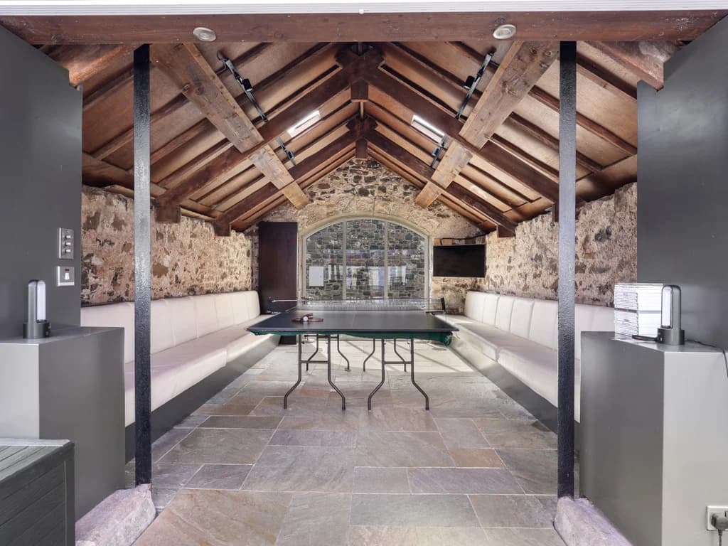 Communal games room with vaulted beams and stone walls