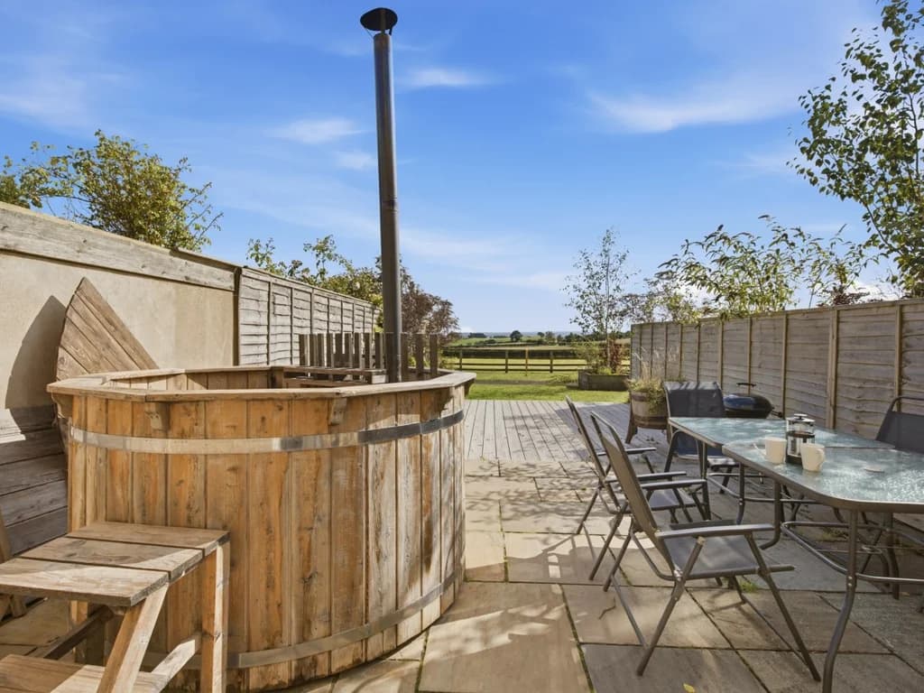 Hayloft patio with wood-fired Scandi hot tub and outdoor dining area