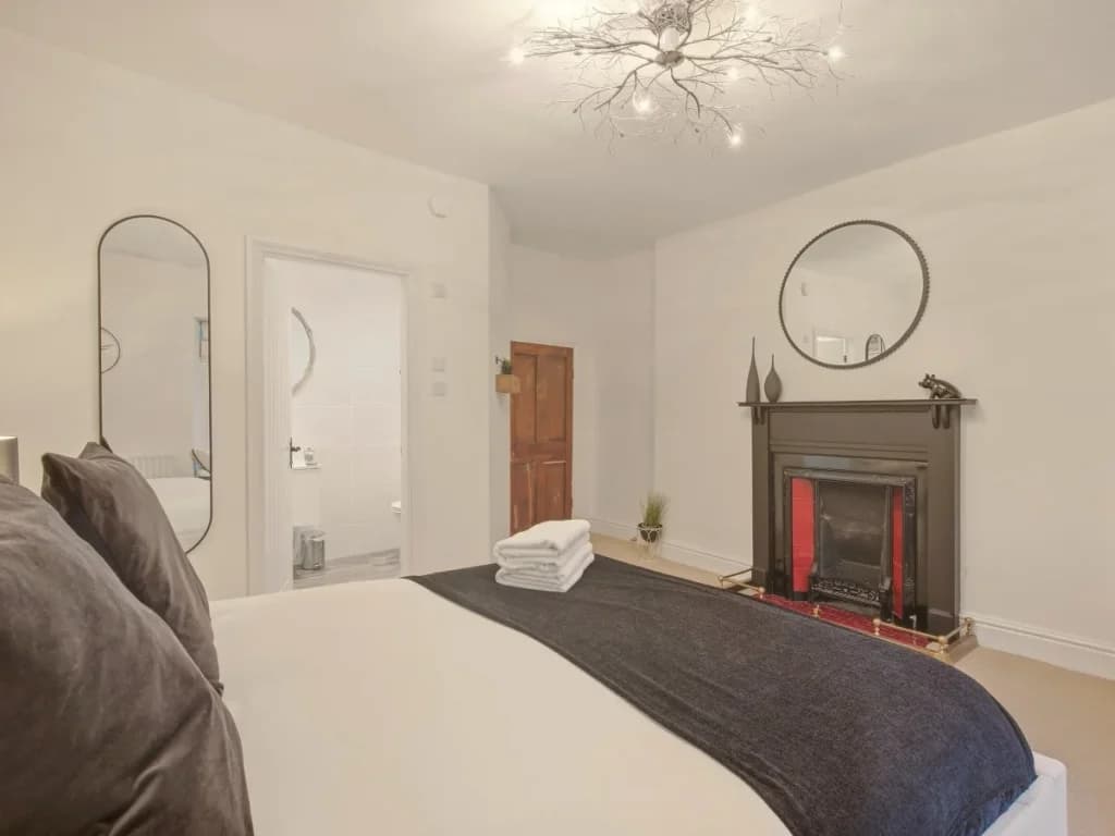 First-floor double bedroom with decorative fireplace and large mirrors.