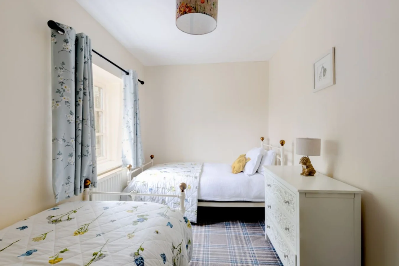 Twin bedroom with cottage-style furnishings and garden-facing window