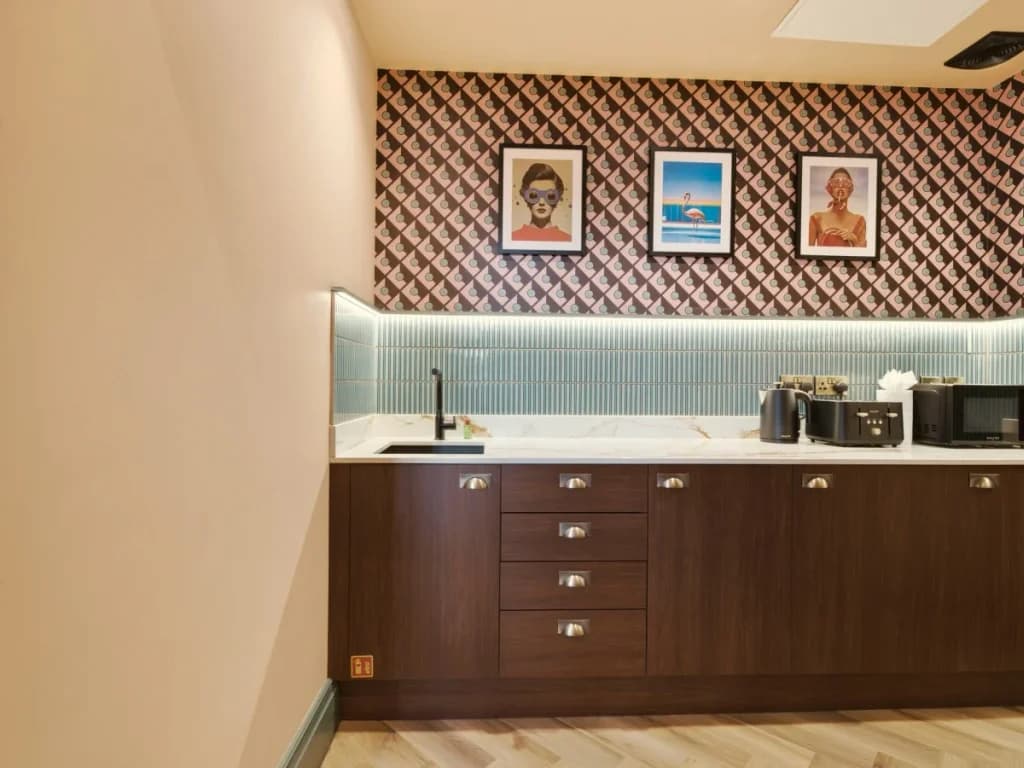 Stylish kitchenette with wood cabinetry, tiled splashback and appliances.