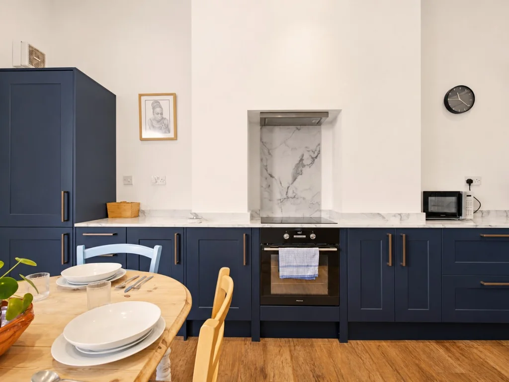 Contemporary kitchen with marble-effect worktops and electric oven.