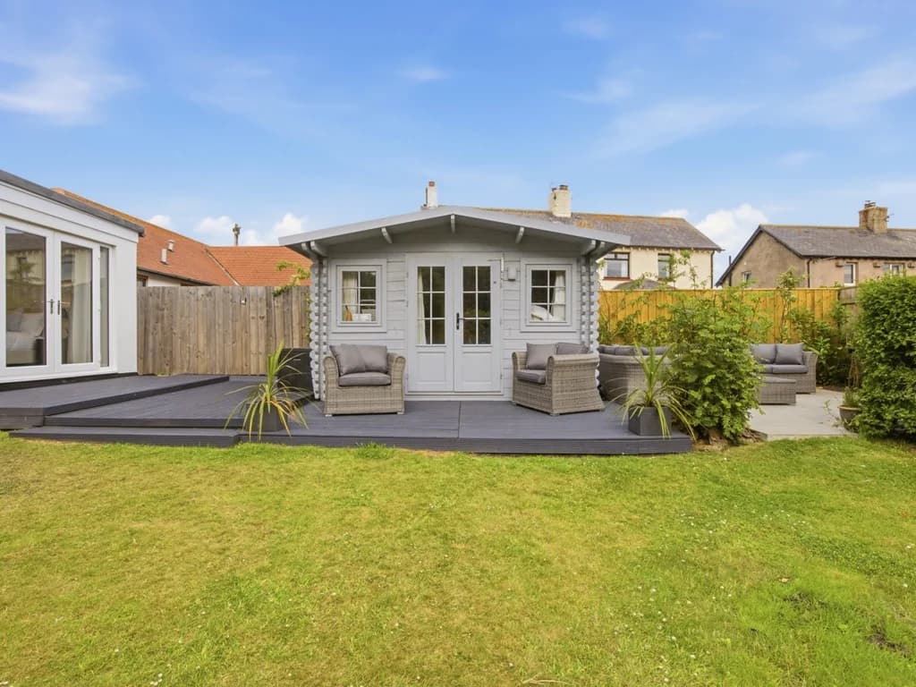 Large enclosed garden with decked terrace and stylish outdoor seating area