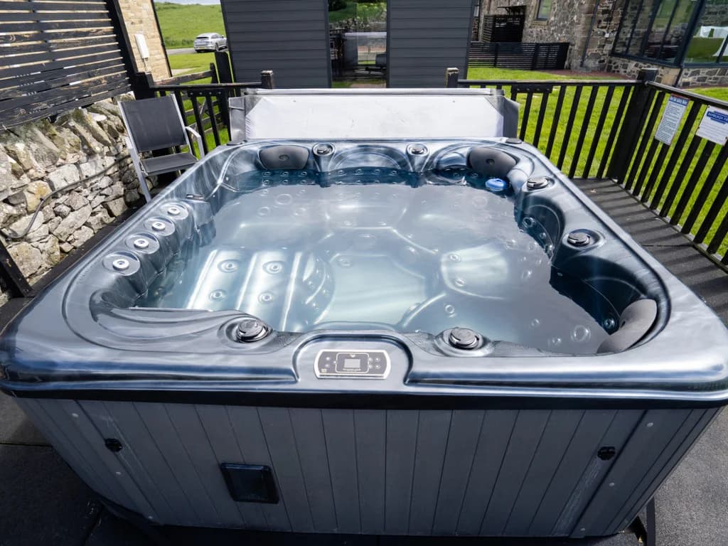 Shared hot tub enclosed by fencing within the courtyard grounds