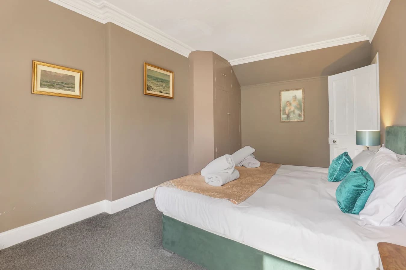Double bedroom with taupe walls, teal accents and soft furnishings