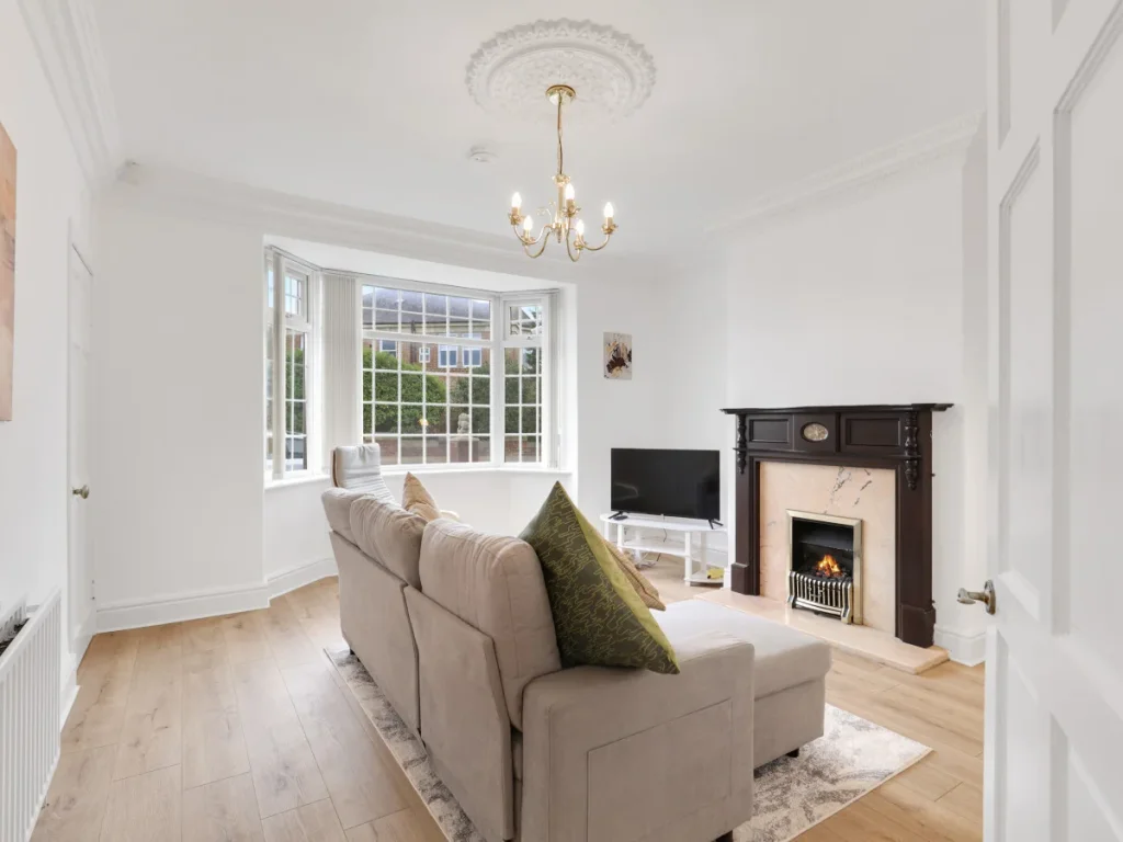 Spacious living room with bay window, corner sofa, TV and fireplace