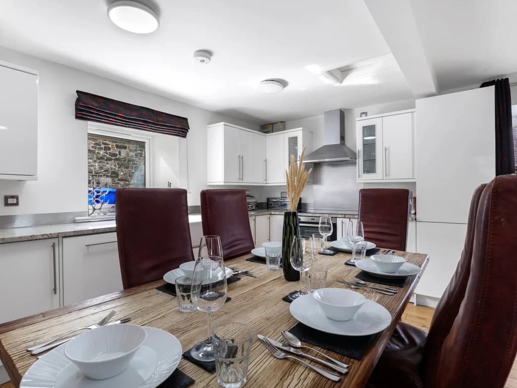 Dining table for six beside the fitted kitchen