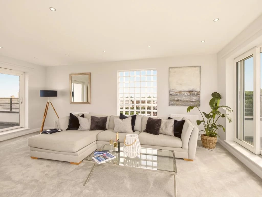 Spacious contemporary lounge with wraparound windows and sea views