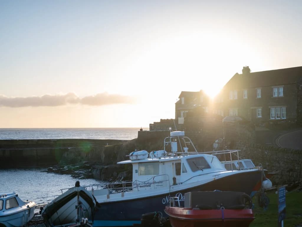 Peaceful harbour scene at sunset, capturing the charm of Craster’s working waterfront.