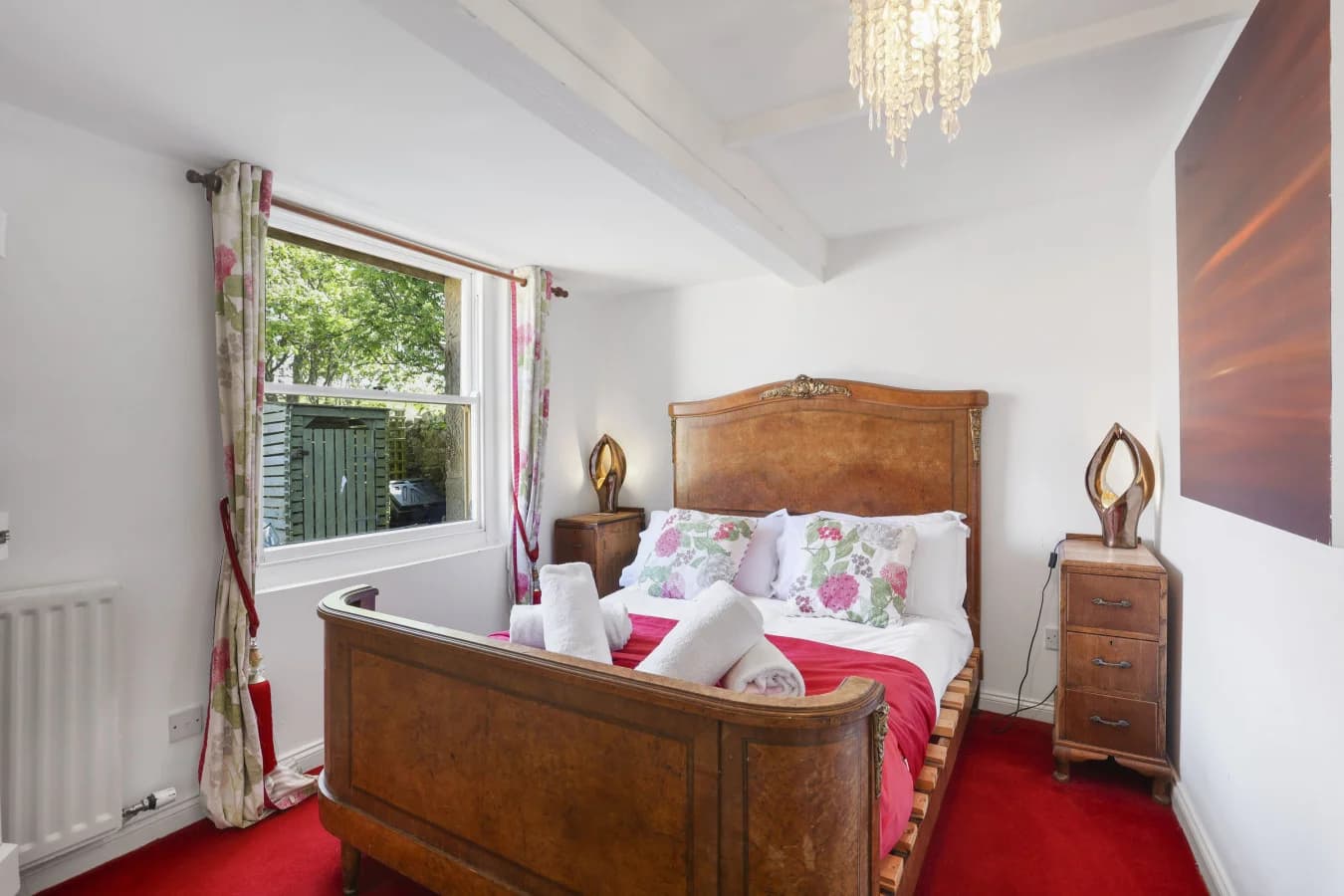 Double bedroom with wooden bed frame and red carpet