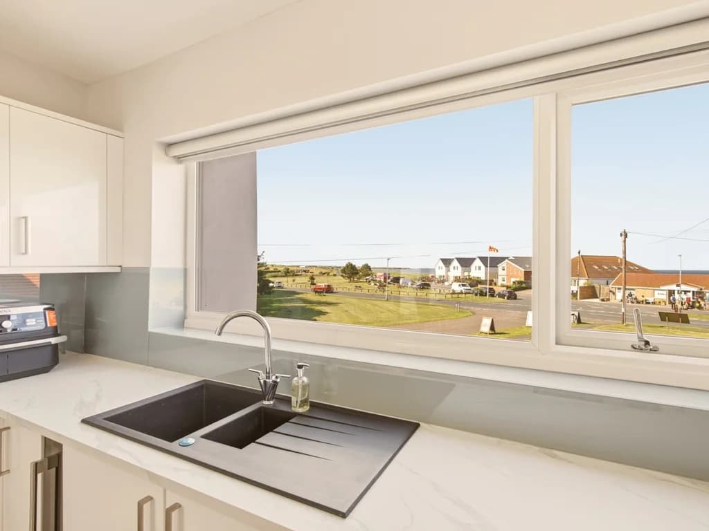 Kitchen window framing lovely views across Beadnell village towards the coastline
