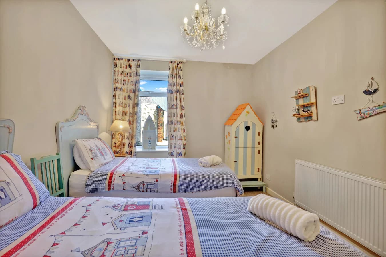Twin bedroom with coastal-inspired furnishings and nautical accents