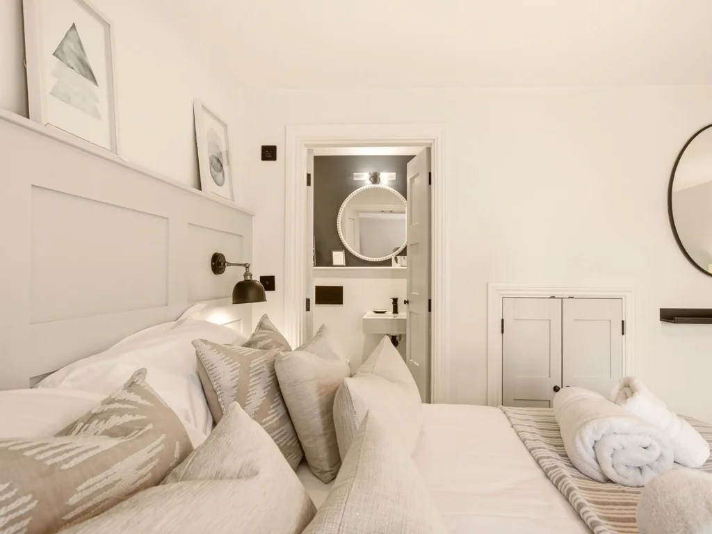 Side view of king bedroom with panelled headboard and en-suite entrance