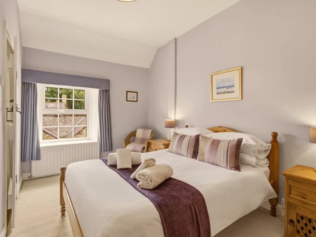 Bright double bedroom with garden views and warm oak bedroom furnishings