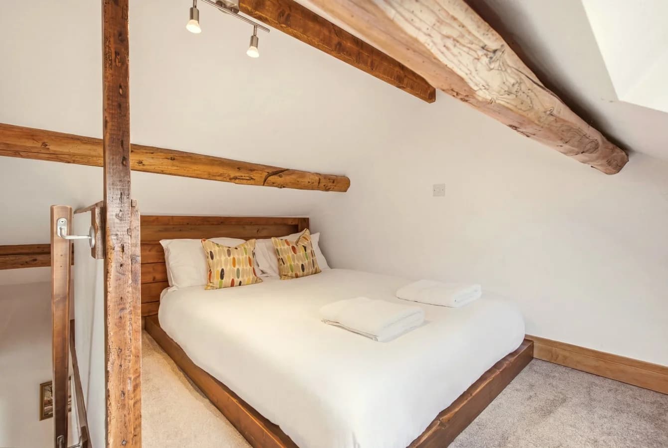 Queen-size Hayloft bed tucked beneath original exposed wooden beams