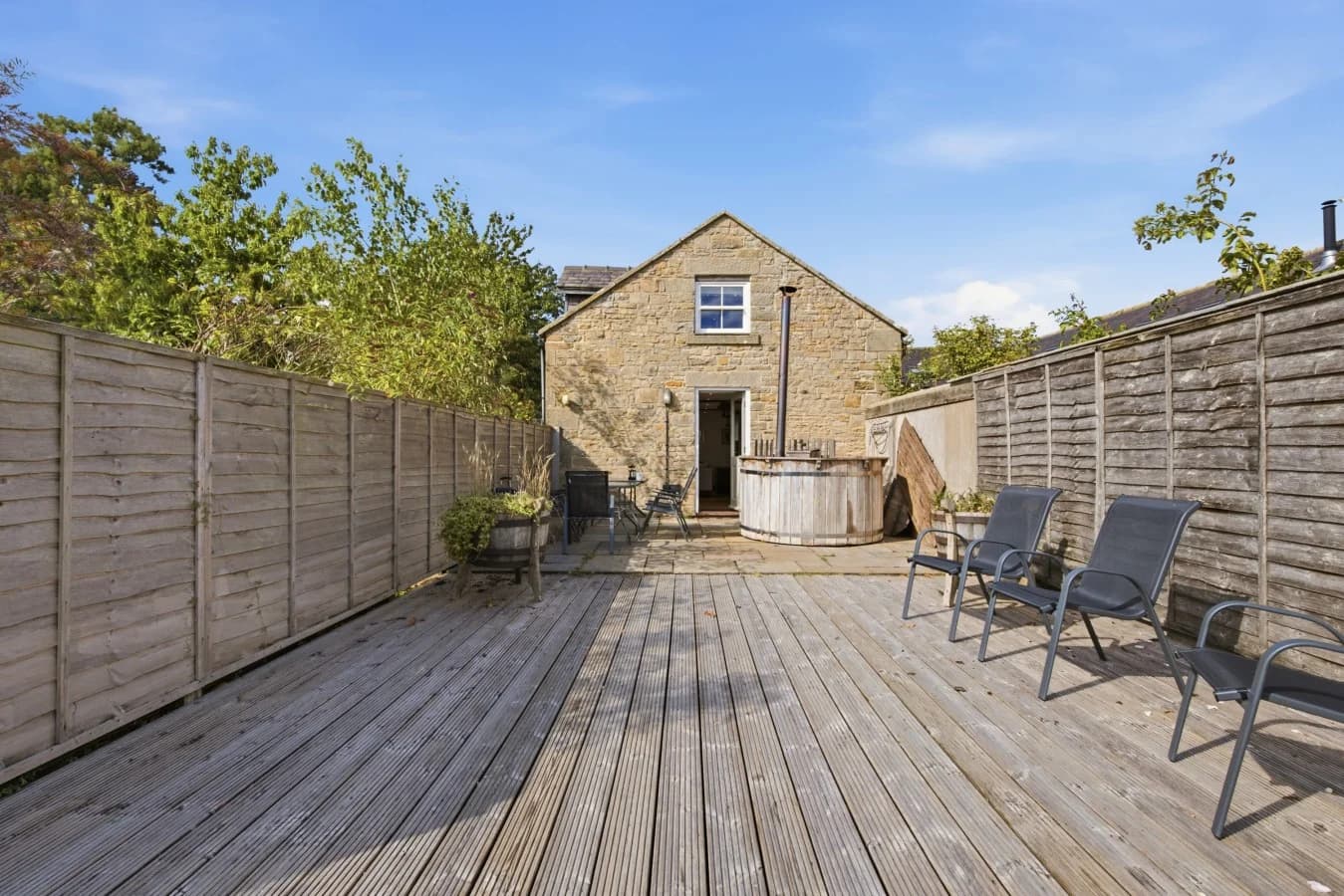 Decked patio with outdoor seating and wood-fired Scandi hot tub