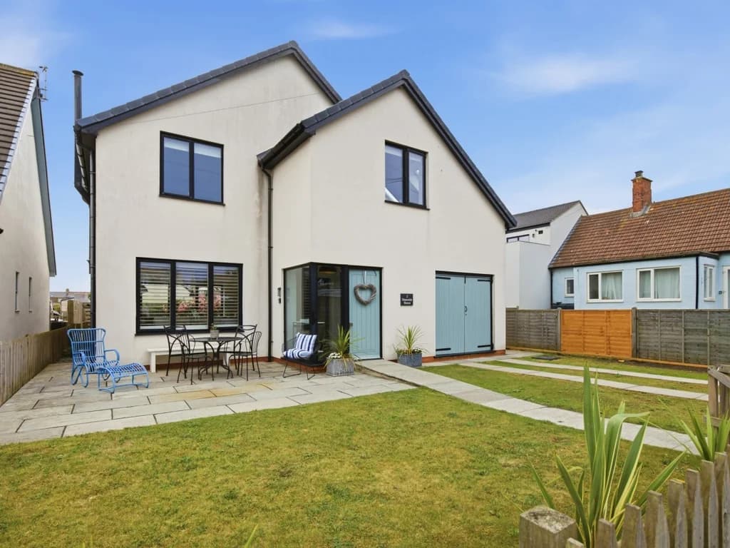 Contemporary rear elevation with lawn, paved patio and outdoor seating area