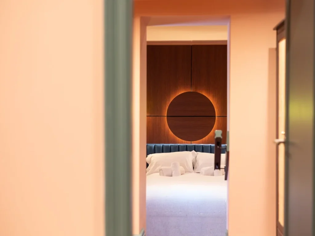 Walkthrough view into the separate bedroom with double bed and fresh towels