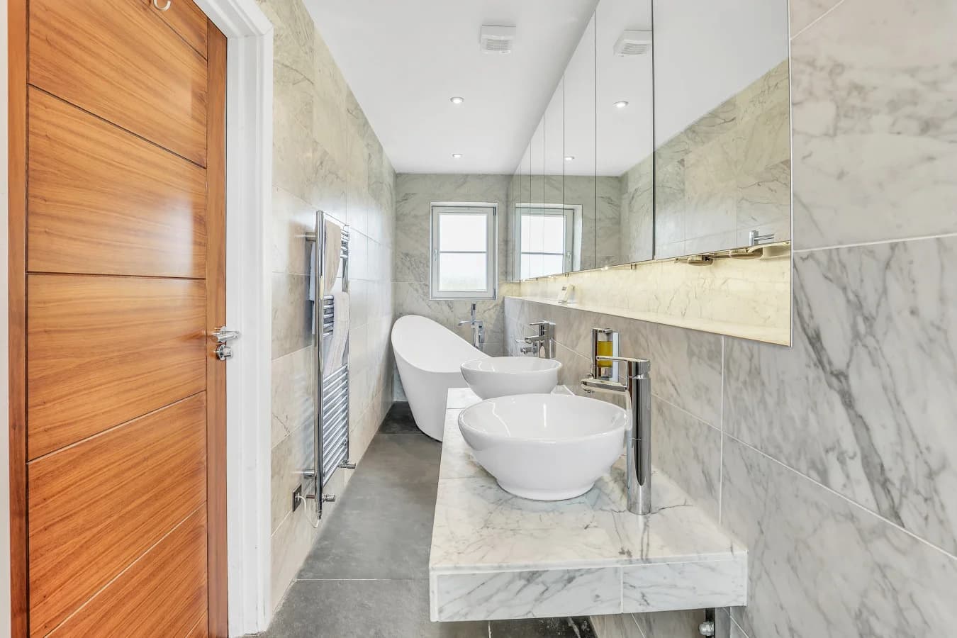 Ensuite with twin basins, marble walls and heated towel rail