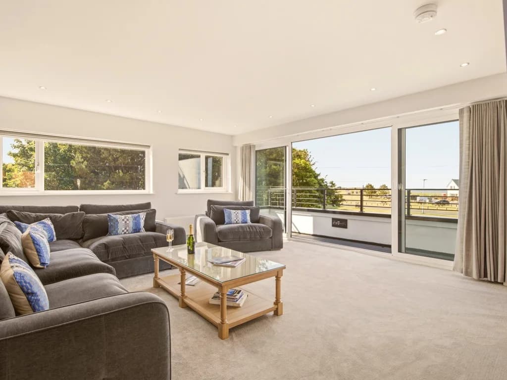 Expansive living space with balcony access and coastal village views