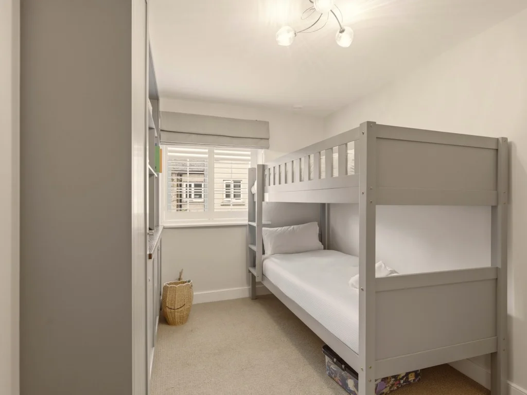 Bright bunk bedroom with built-in wardrobe and soft neutral décor