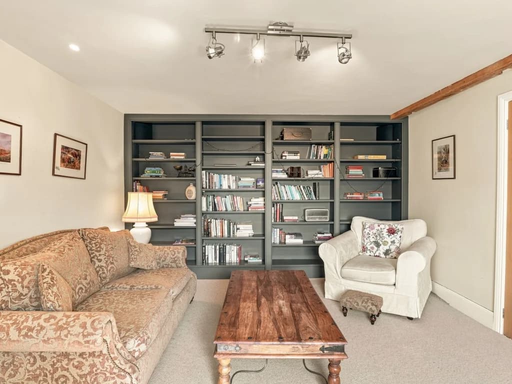 Living room with full bookshelves, patterned sofa and armchair