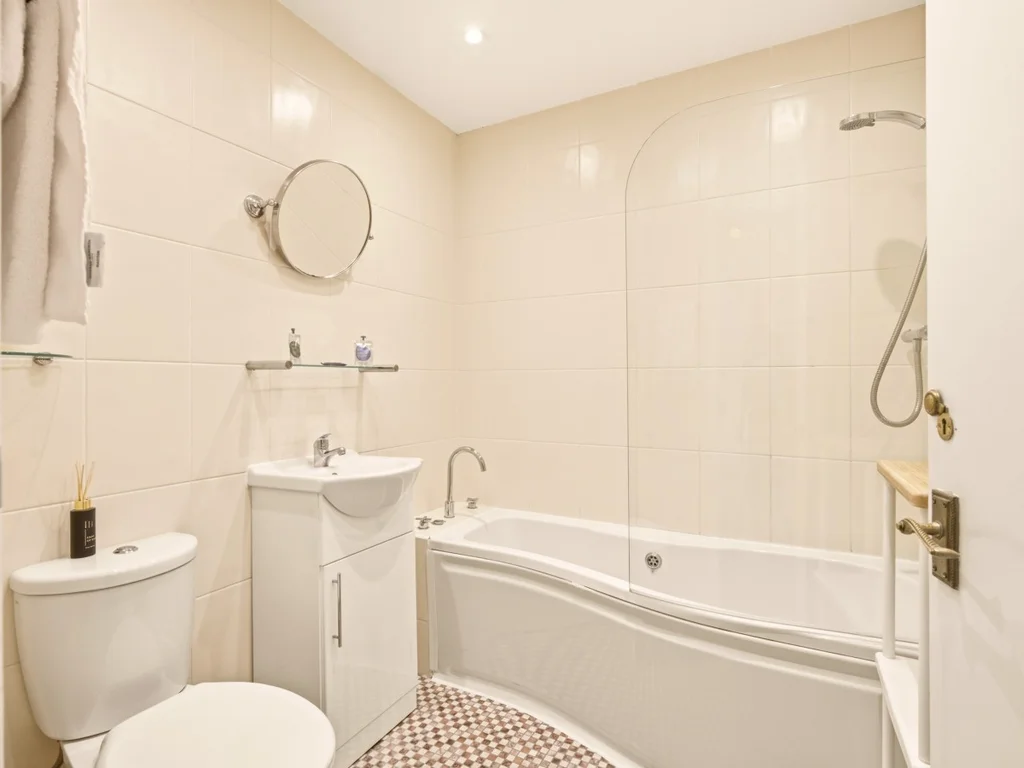 Family bathroom with shower over bath and vanity storage.