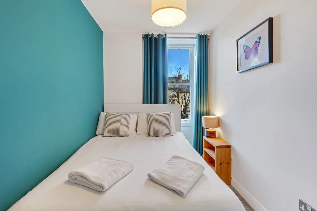 Contemporary bedroom with colourful artwork and rich teal accents