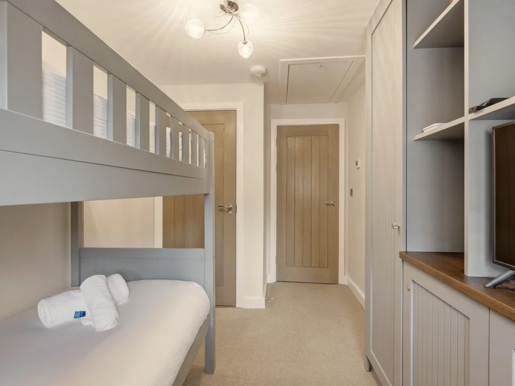 Cosy bunk bedroom with built-in storage and Smart TV for added comfort