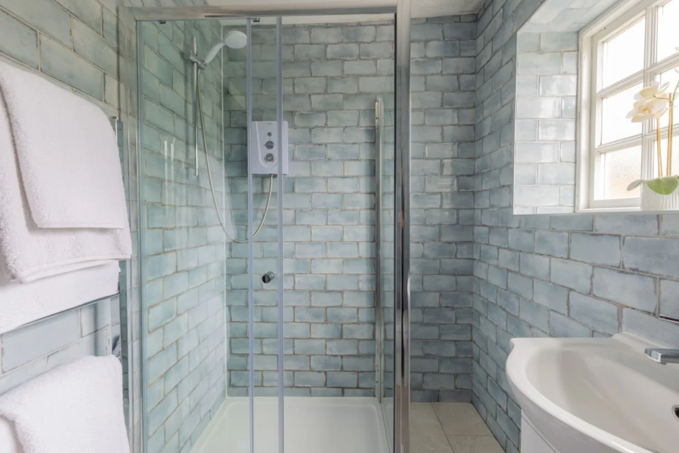 Walk-in rainfall shower finished with textured blue metro tiles
