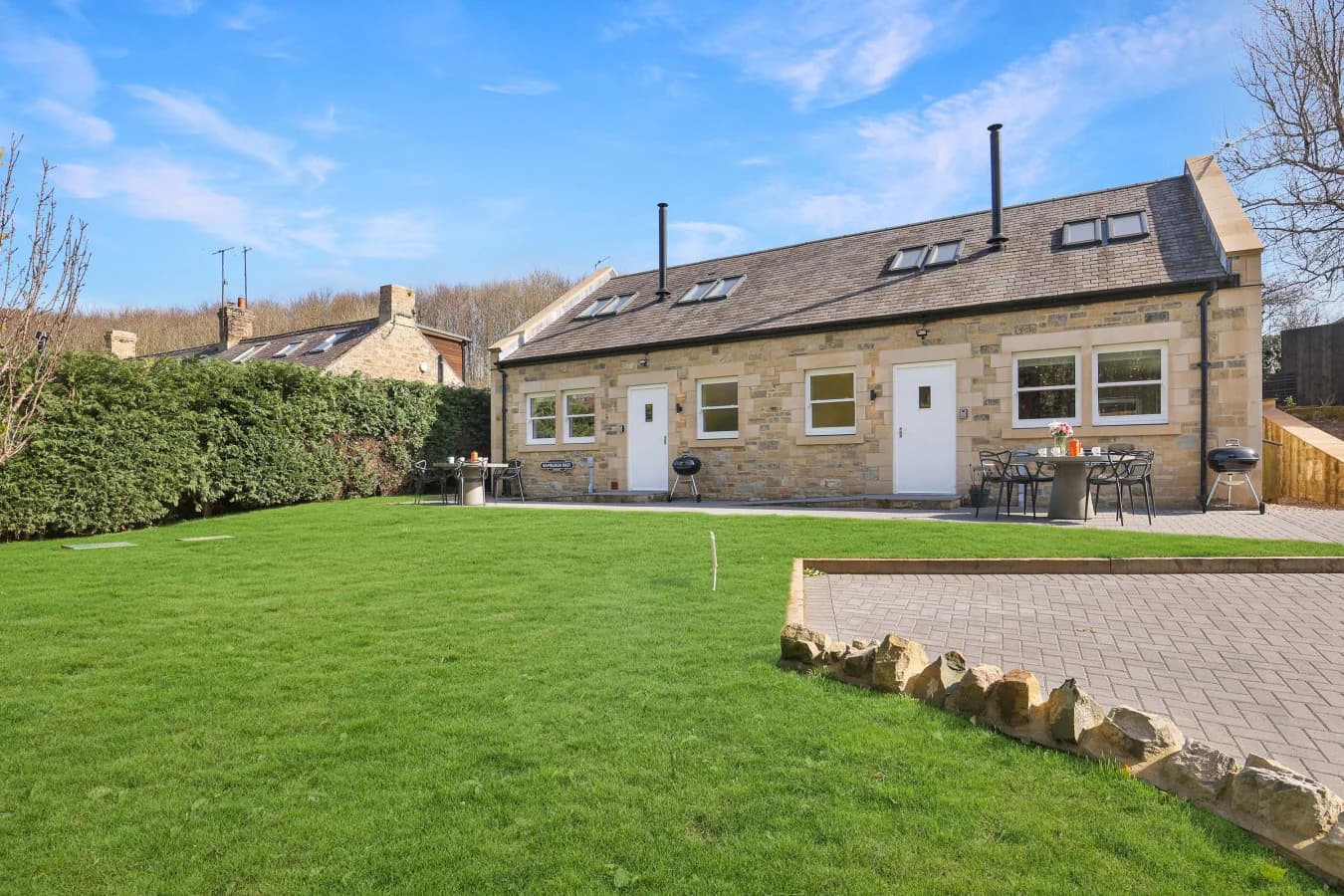 Cottage patio and shared lawn with sandstone exterior