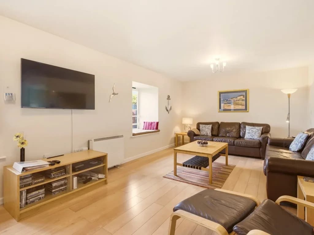 Bright living room with leather sofas, Smart TV and wooden coffee table