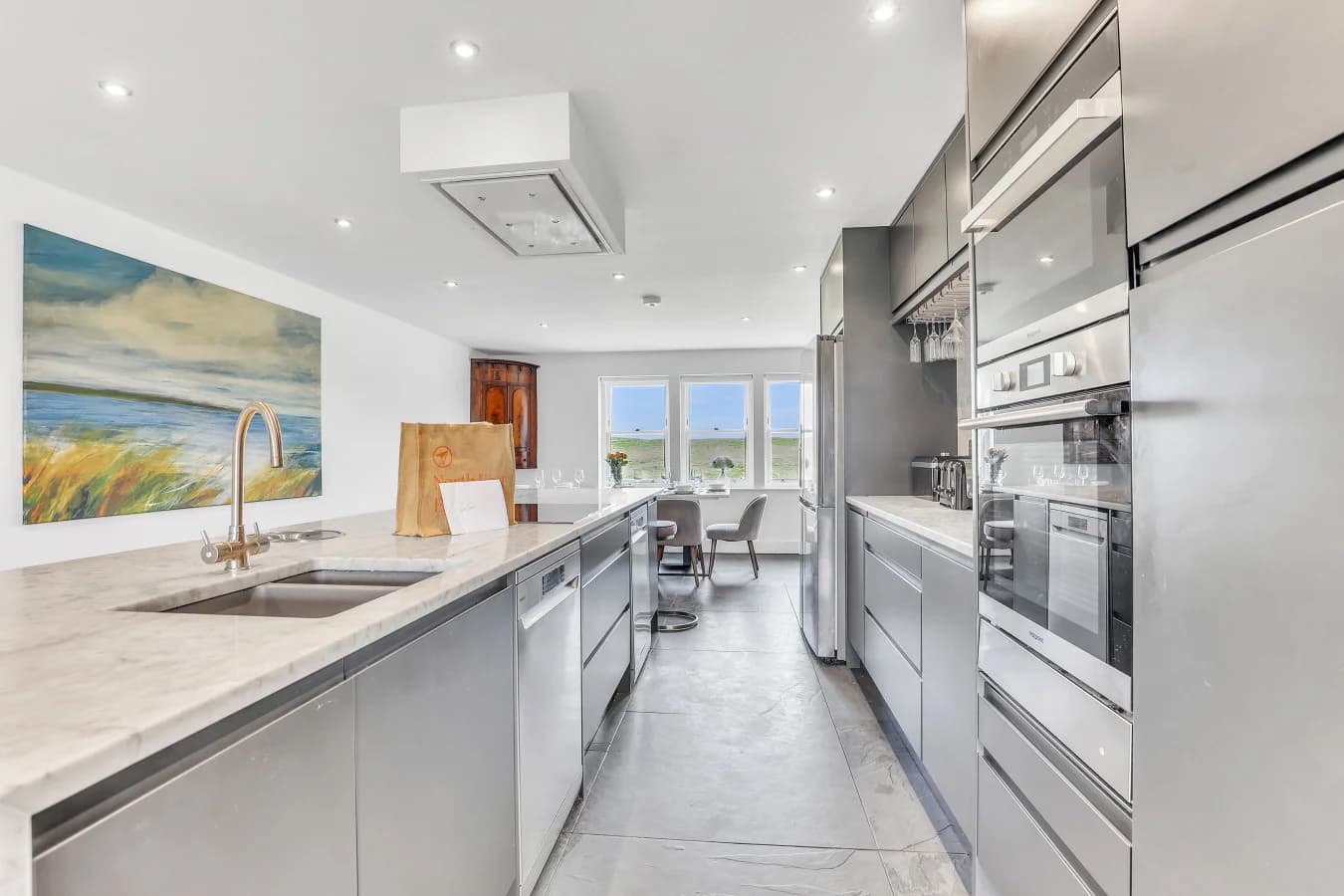 Contemporary kitchen with marble island and integrated appliances
