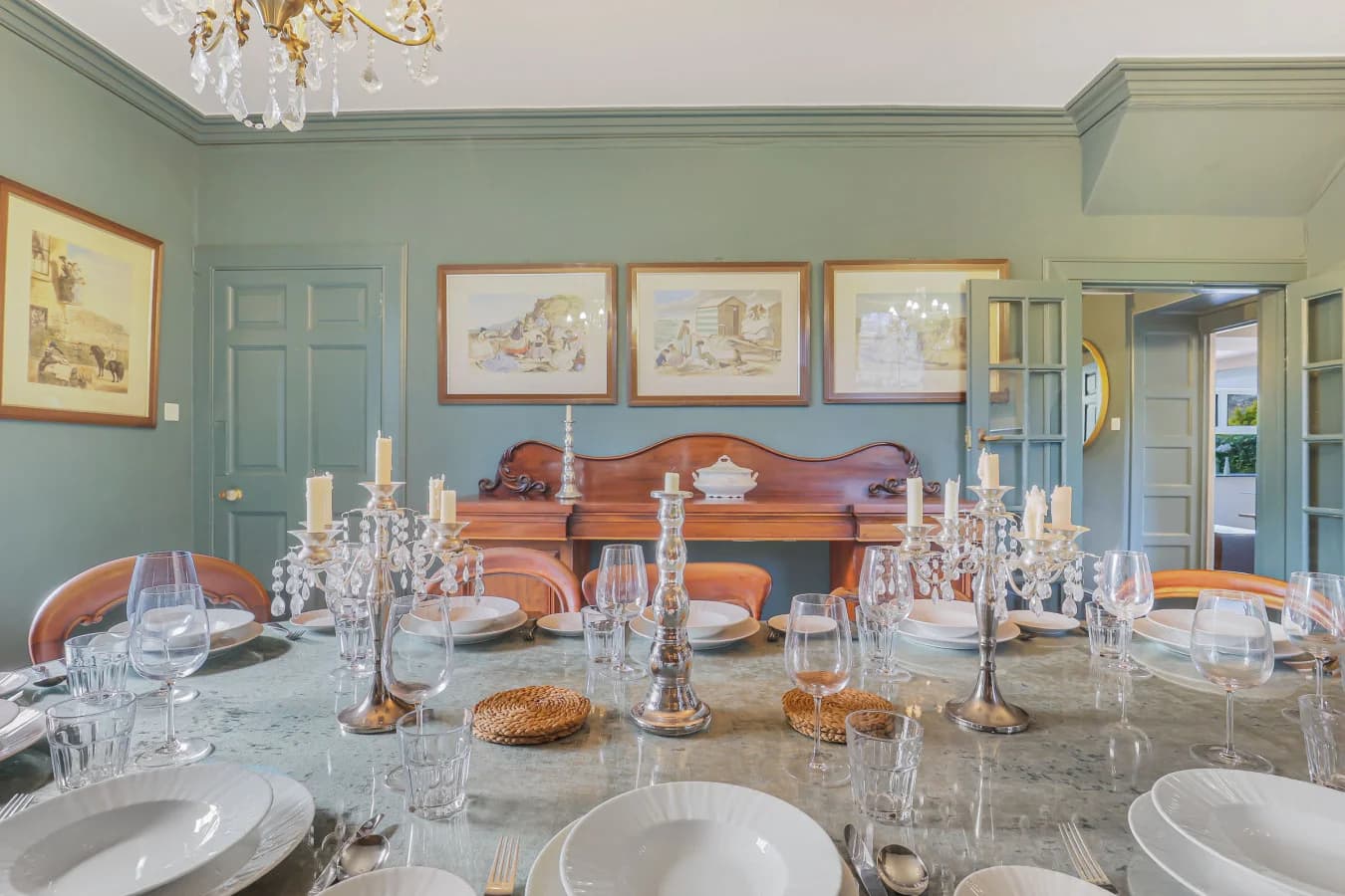 Dining table set for ten with teal panelling and vintage sideboard