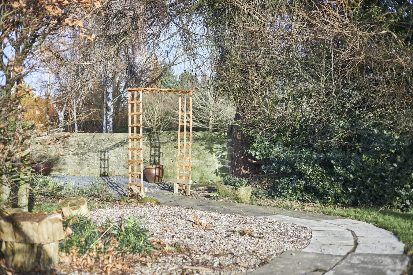 Sheltered seating area tucked among established trees and greenery