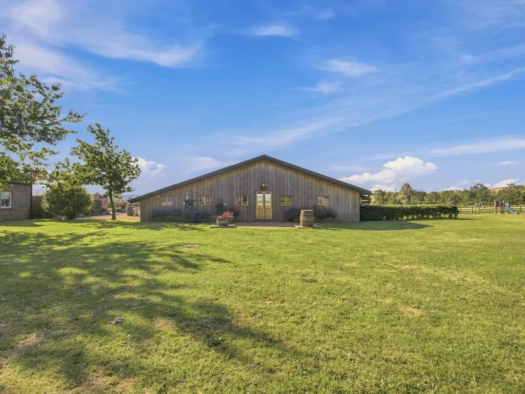 The Big Barn set across expansive lawns beneath open countryside skies