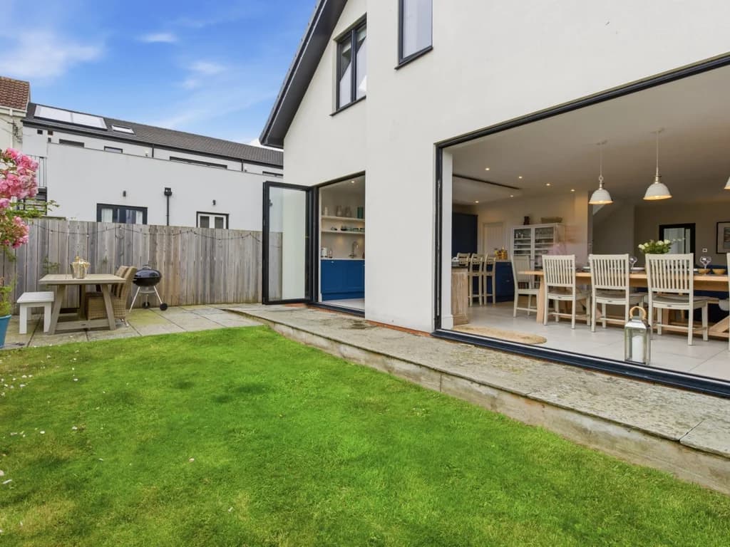 Rear garden with lawn, picnic bench and sliding doors to the dining area